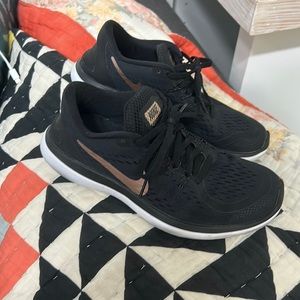 Nike black shoes with rose gold logo